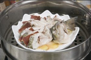 將鱸魚成花狀擺好，將火腿切片放入各縫隙中，放入鍋中隔水蒸12分鐘拿出，撒上蔥花即可。