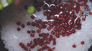 將炒好的食材和大米、紅豆一起放進(jìn)電飯鍋煮。