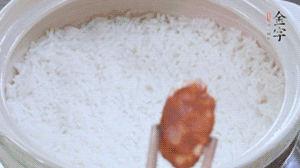 煮開后轉小火，當米飯出現(xiàn)小孔時，鋪上金字麻辣香腸。
