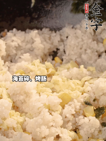 剩米飯下鍋炒散，依次下玉米粒、雞蛋、烤腸、海苔碎翻炒均勻。
