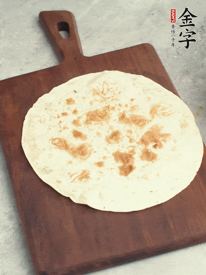 食材依次鋪在卷餅皮上，卷起來(lái)。