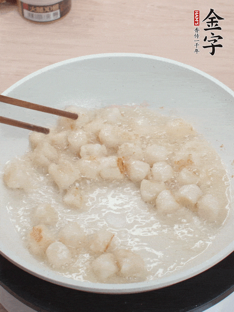 油溫4成熱，鮮貝蘸干淀粉下鍋煎，一面微黃后翻面。
