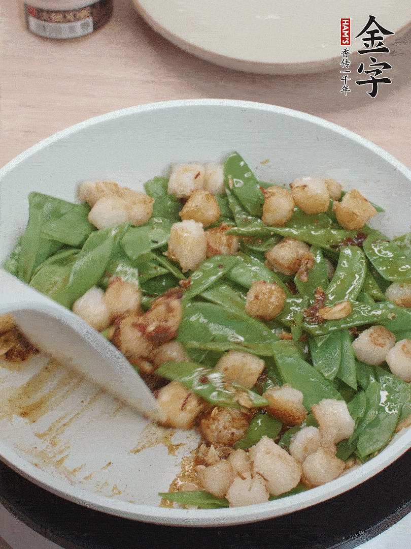 下甜豆莢、鮮貝輕輕翻炒均勻。