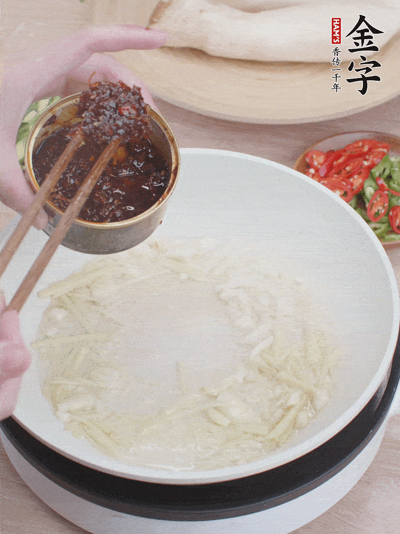 起鍋熱油，姜蒜、金字火腿干貝醬煸香。