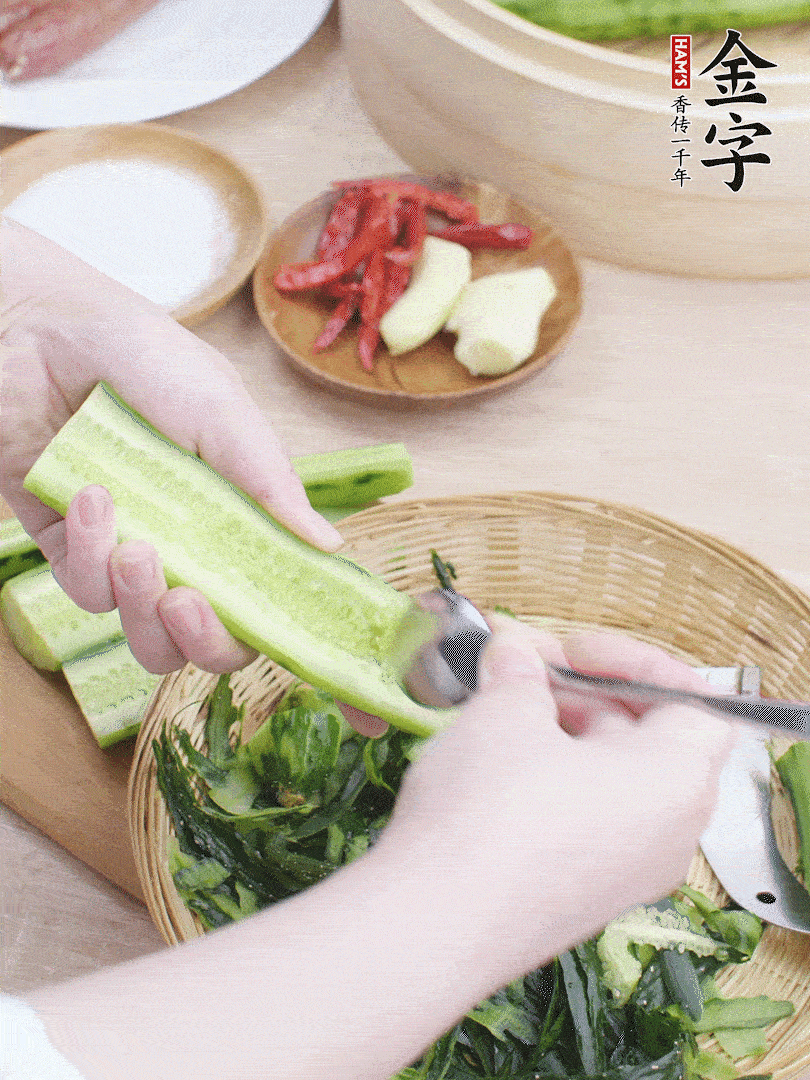 黃瓜削皮，對(duì)半切開(kāi)，勺子挖去內(nèi)瓤，斜刀切片。青蒜斜刀切段。
