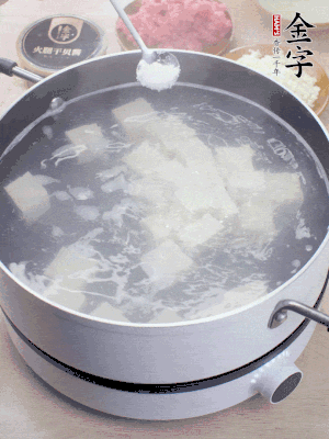 豆腐切成大小均勻正方體，鍋內(nèi)放水，加一點鹽焯水10秒。