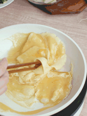 油6成熱時(shí)，下雞蛋液，邊緣凝固時(shí)翻拌成塊狀。