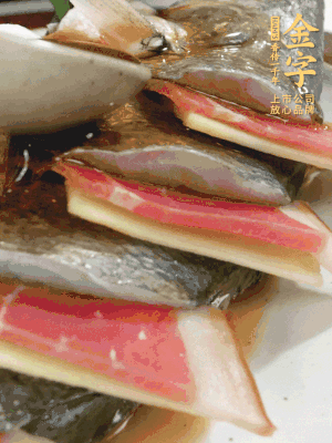 魚肚中塞蔥結(jié)、火腿片，魚身上碼放姜片、火腿片，倒入混合的料汁。